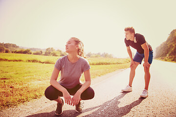 Image showing young couple warming up and stretching on a country road