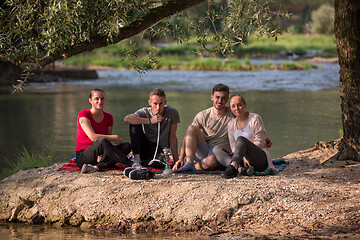 Image showing friends smoking hookah on the river bank