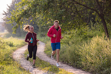 Image showing young couple jogging along a country road