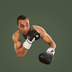 Image showing Sporty man during boxing exercise. Photo of boxer on green background