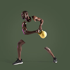 Image showing Young african-american bodybuilder training over green background