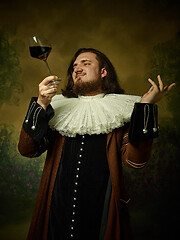 Image showing Young man as a medieval knight on dark background