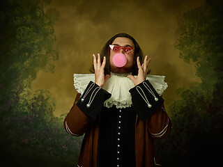 Image showing Young man as a medieval knight on dark background