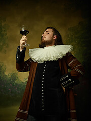 Image showing Young man as a medieval knight on dark background