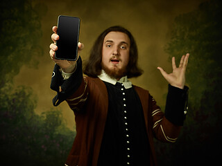 Image showing Young man as a medieval knight on dark background