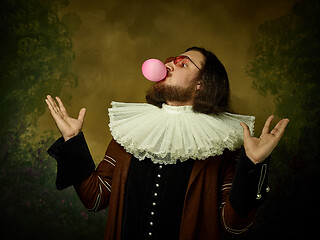 Image showing Young man as a medieval knight on dark background