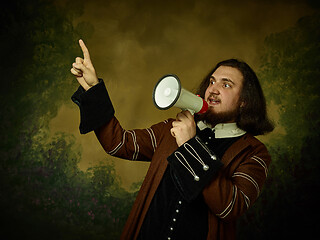 Image showing Young man as a medieval knight on dark background