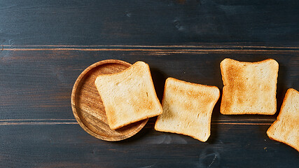 Image showing toasted bread slices on rustic wooden table