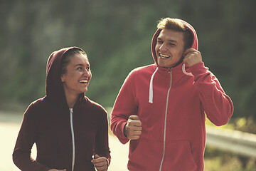 Image showing young couple jogging along a country road