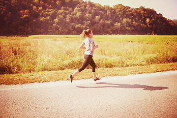 Image showing woman jogging along a country road