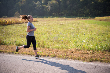 Image showing woman jogging along a country road