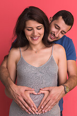 Image showing pregnant  couple showing heart with their hands