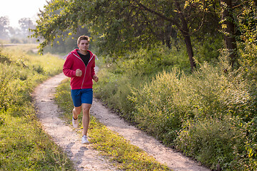 Image showing man jogging along a country road