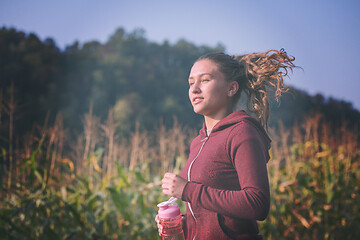 Image showing woman jogging along a country road