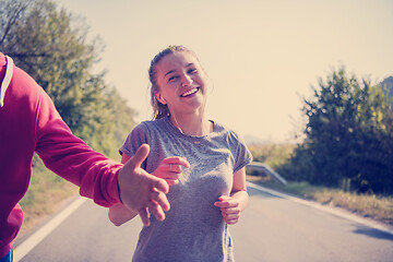 Image showing young couple jogging along a country road