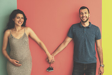 Image showing young happy couple holding newborn baby shoes