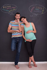 Image showing pregnant couple writing on a black chalkboard