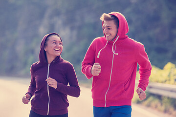 Image showing young couple jogging along a country road