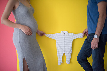 Image showing young couple holding baby bodysuits