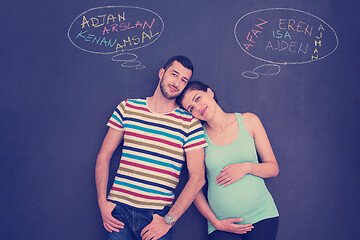 Image showing pregnant couple writing on a black chalkboard