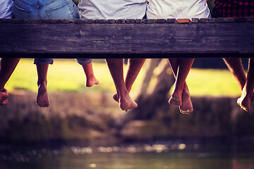 Image showing people sitting at wooden bridge