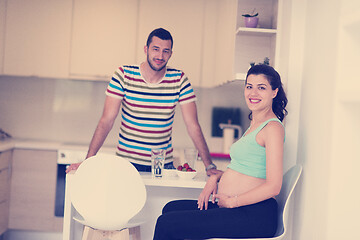 Image showing couple eating fruit strawberries at kitchen