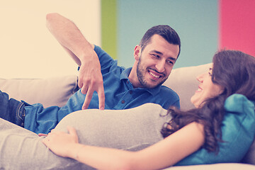 Image showing young pregnant couple relaxing on sofa