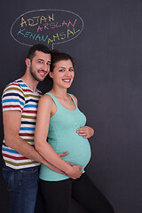 Image showing pregnant couple writing on a black chalkboard