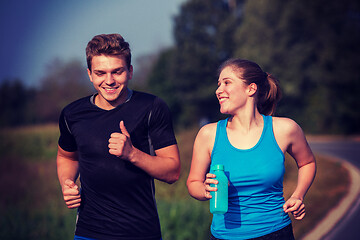 Image showing young couple jogging along a country road