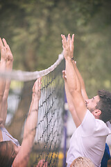 Image showing group of young friends playing Beach volleyball