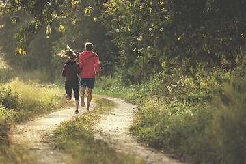 Image showing young couple jogging along a country road