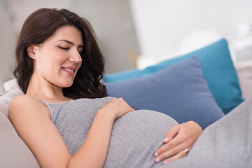 Image showing pregnant woman sitting on sofa at home