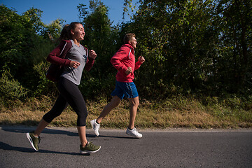 Image showing young couple jogging along a country road