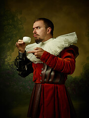 Image showing Young man as a medieval knight on dark background