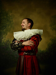 Image showing Young man as a medieval knight on dark background