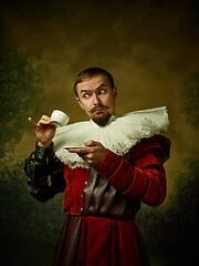 Image showing Young man as a medieval knight on dark background