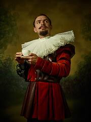 Image showing Young man as a medieval knight on dark background