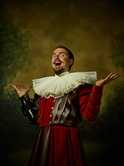 Image showing Young man as a medieval knight on dark background