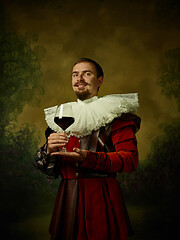 Image showing Young man as a medieval knight on dark background