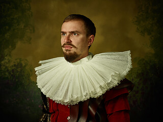 Image showing Young man as a medieval knight on dark background