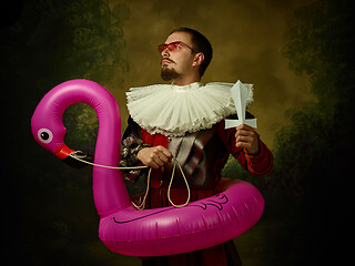 Image showing Young man as a medieval knight on dark background