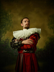 Image showing Young man as a medieval knight on dark background