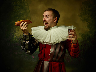 Image showing Young man as a medieval knight on dark background