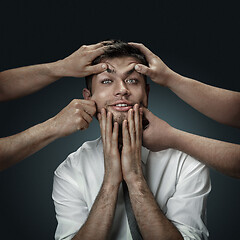 Image showing A young man surrounded by hands like his own thoughts