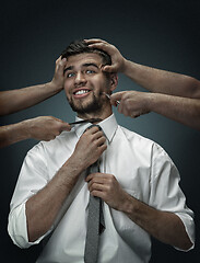 Image showing A young man surrounded by hands like his own thoughts