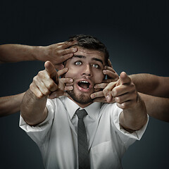 Image showing A young man surrounded by hands like his own thoughts