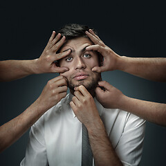 Image showing A young man surrounded by hands like his own thoughts