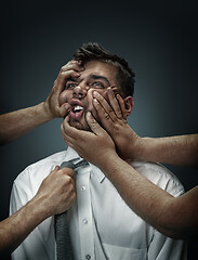 Image showing A young man surrounded by hands like his own thoughts