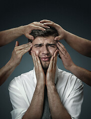 Image showing A young man surrounded by hands like his own thoughts