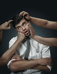 Image showing A young man surrounded by hands like his own thoughts